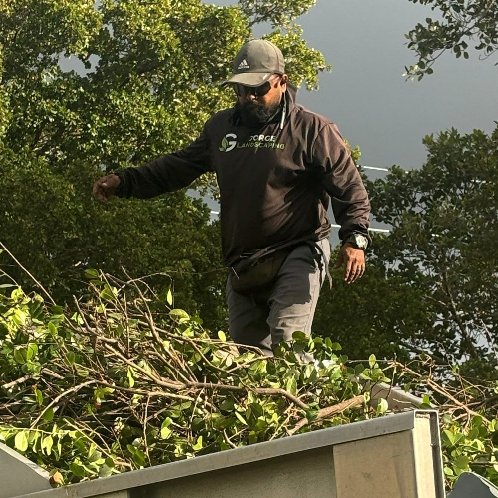 Jorge loading trimmed branches onto the Jorge G Landscaping truck